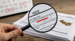 Moduli ISEE su un tavolo con lente d'ingrandimento e calendario sullo sfondo