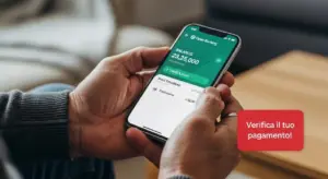 Persona controlla il saldo e la tredicesima sullo smartphone tramite app bancaria